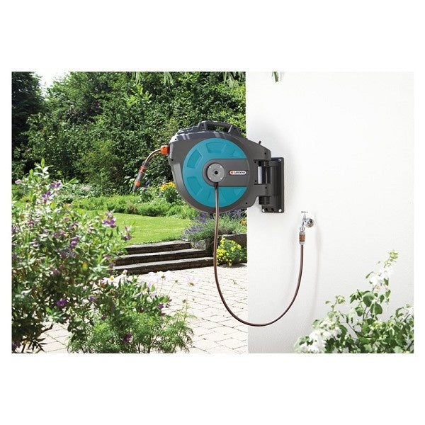 Gardena wand-gemonteerde slangenbox met oprolmechanisme, slang uitgaand naar de tuin.