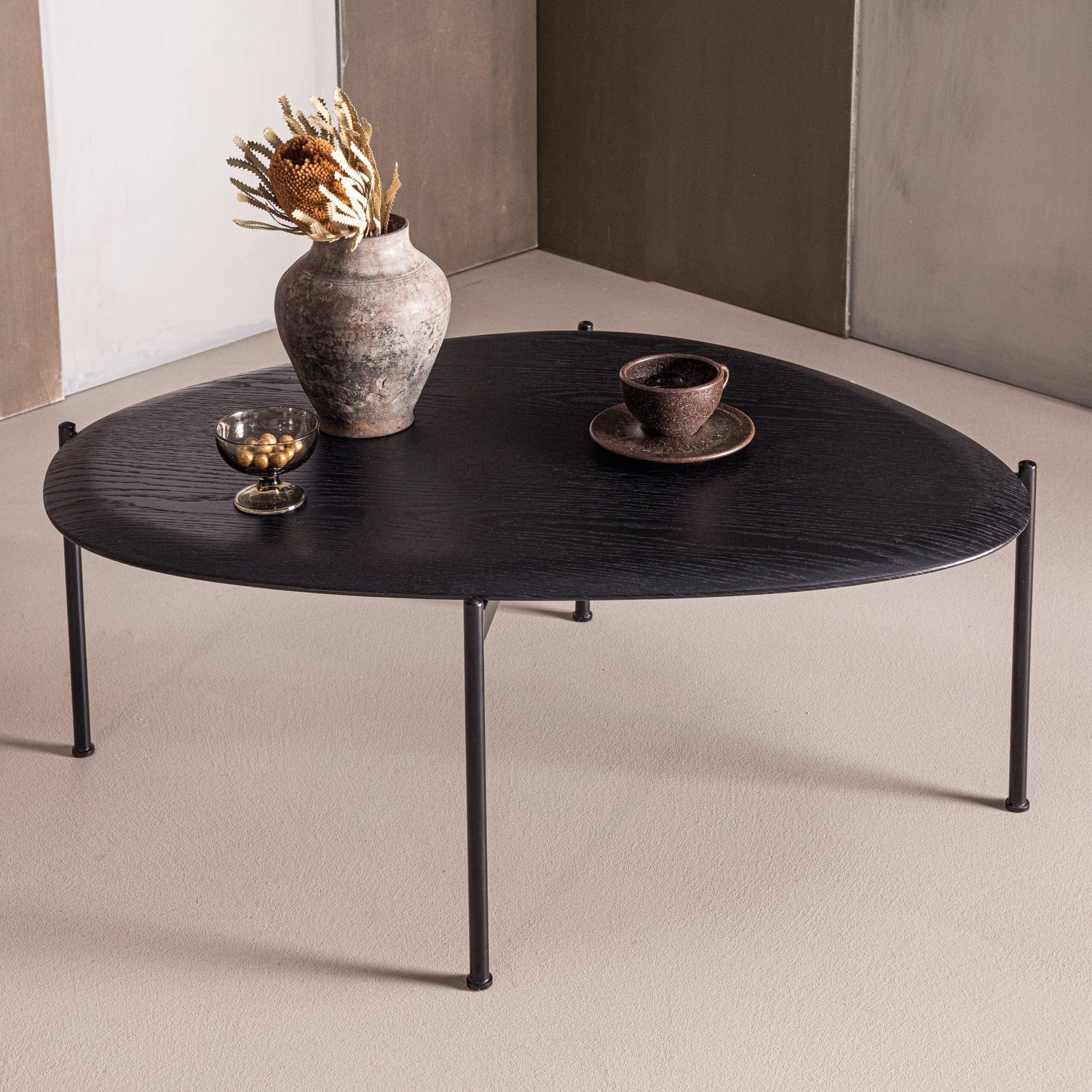 Zwarte ovale salontafel met houten blad en vier metalen poten