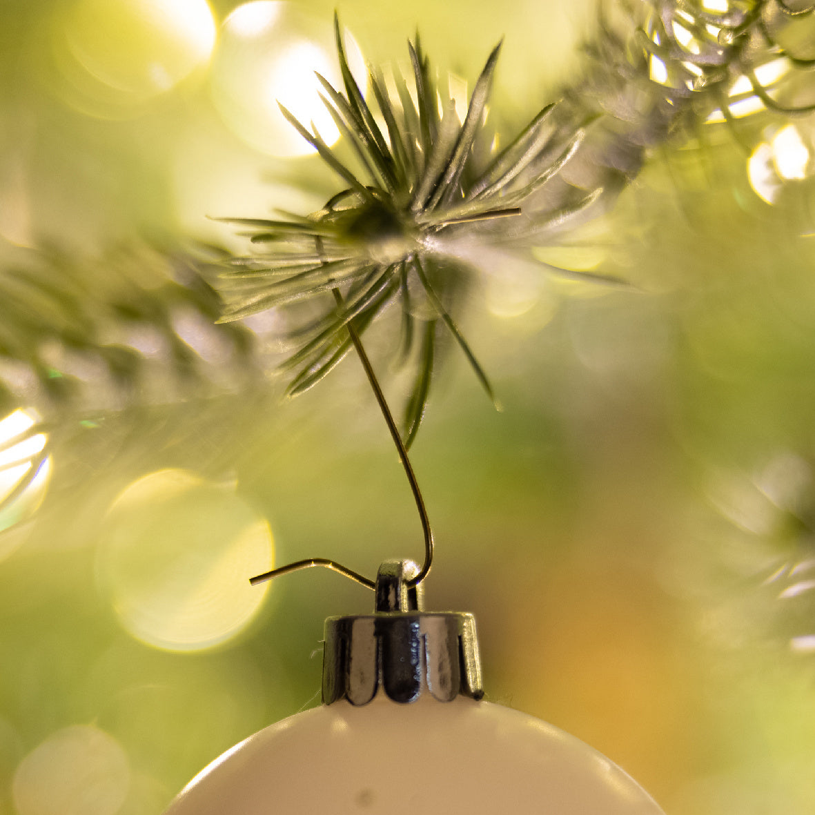 Kerstbalhaakje van ijzer met metalen klem en punt op witte kerstbal