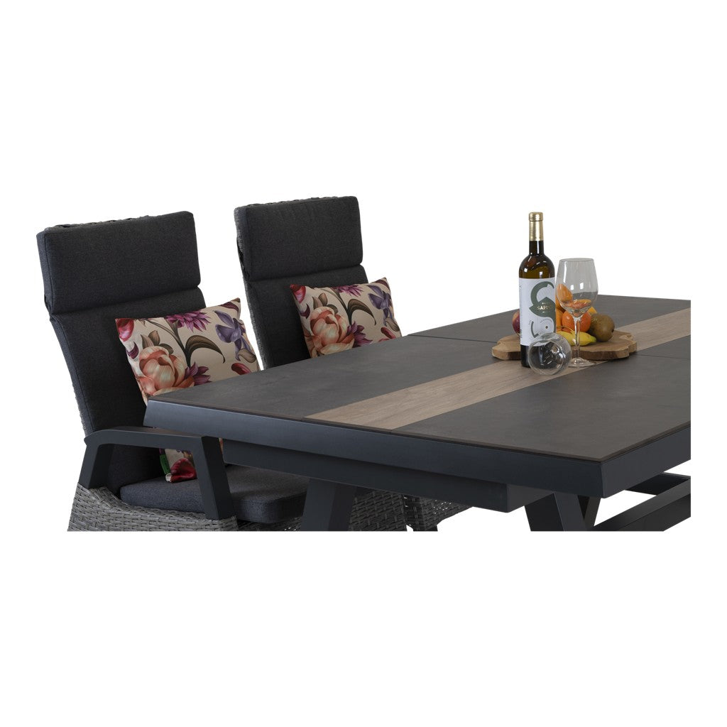 Uittrektafel met grijze stoelen en bloemenkussens, tafel met fles en glazen