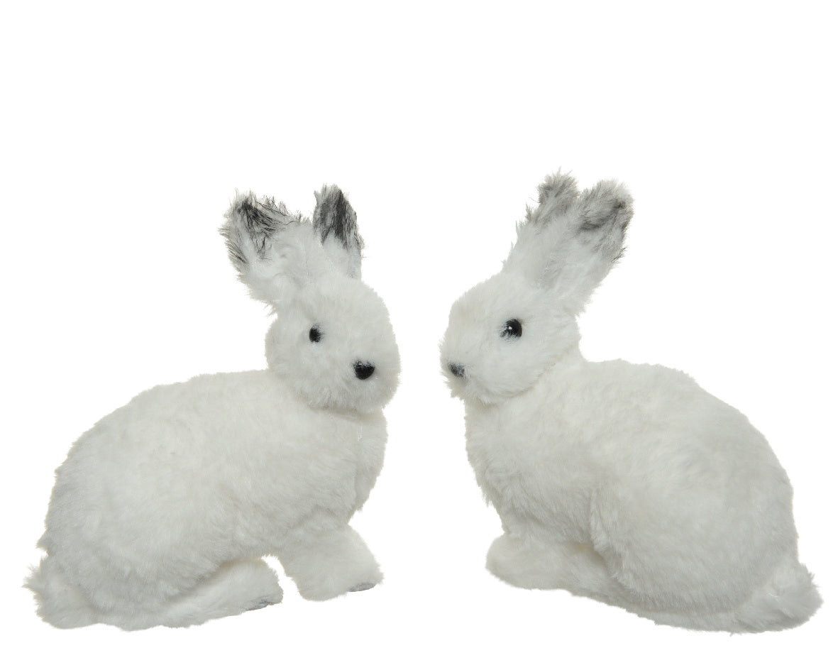 Twee witte pluizige konijnen van foam, zittend, met zwarte oogjes en neus.