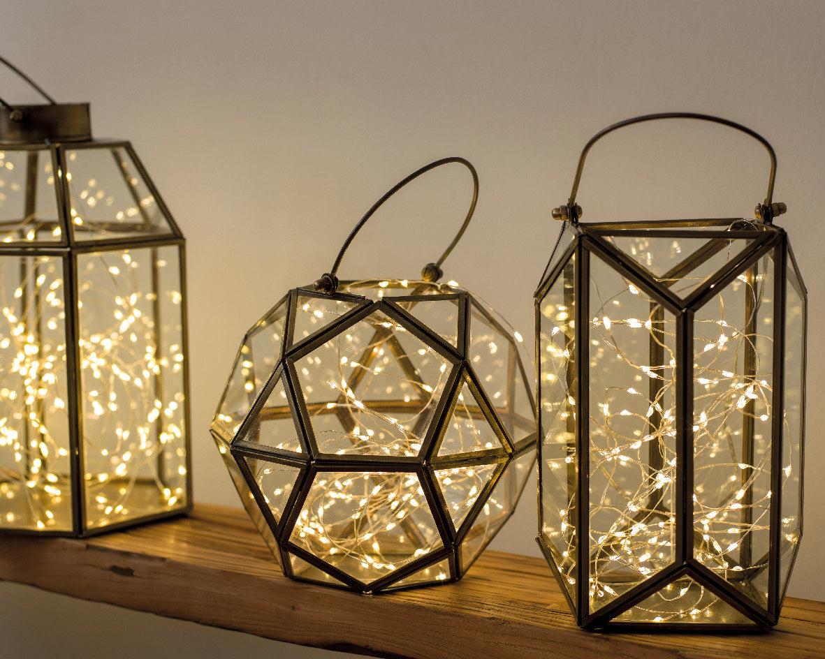 Micro-LED lichtsnoer in zwarte lantaarns met warmwitte lichtpuntjes op hout