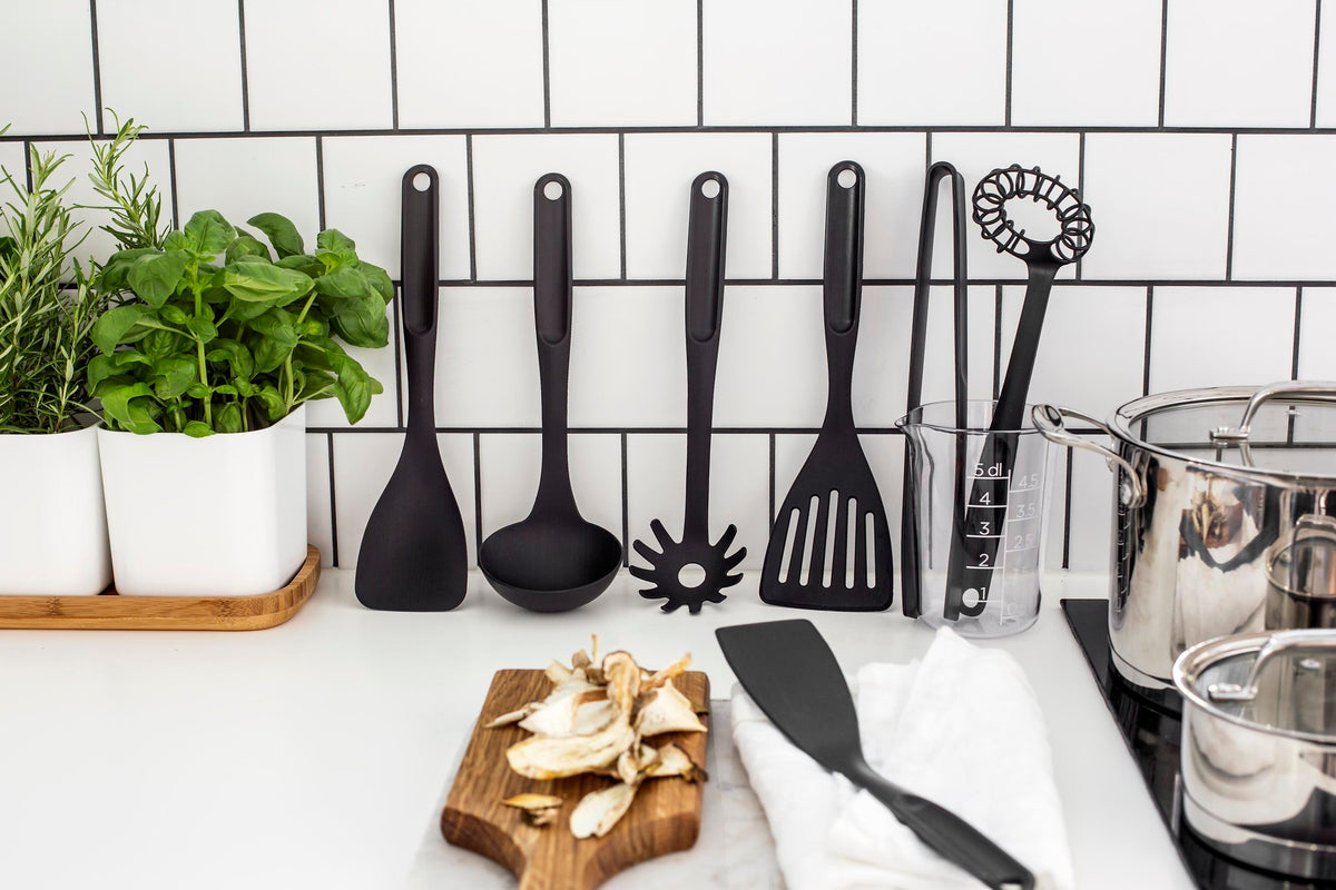 GastroMax nylon spatel met sleuven tussen zwarte keukengereedschappen