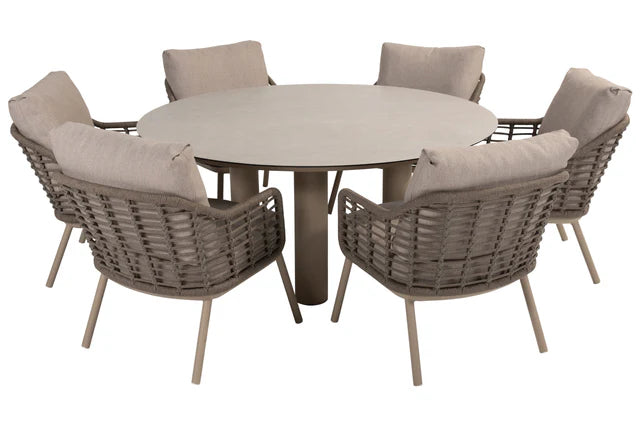 Ronde lage eettafel met grijze gevlochten stoelen en beige kussens