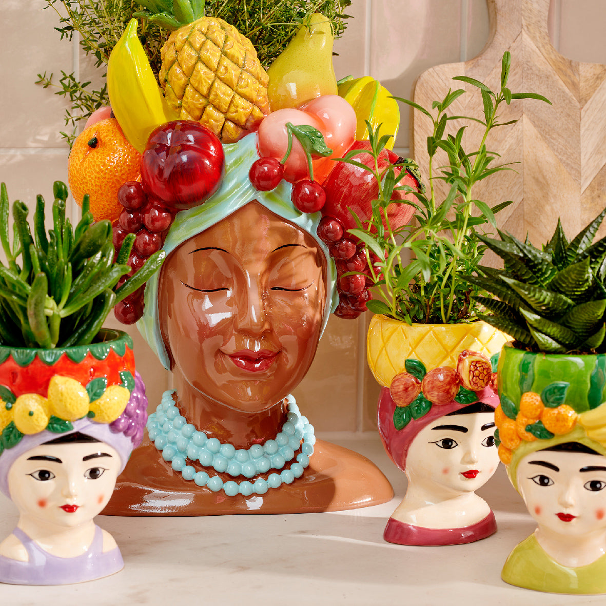 Dolomiet bloempot met vrouwenhoofd, blauwe parelketting en fruitdecor, assorti