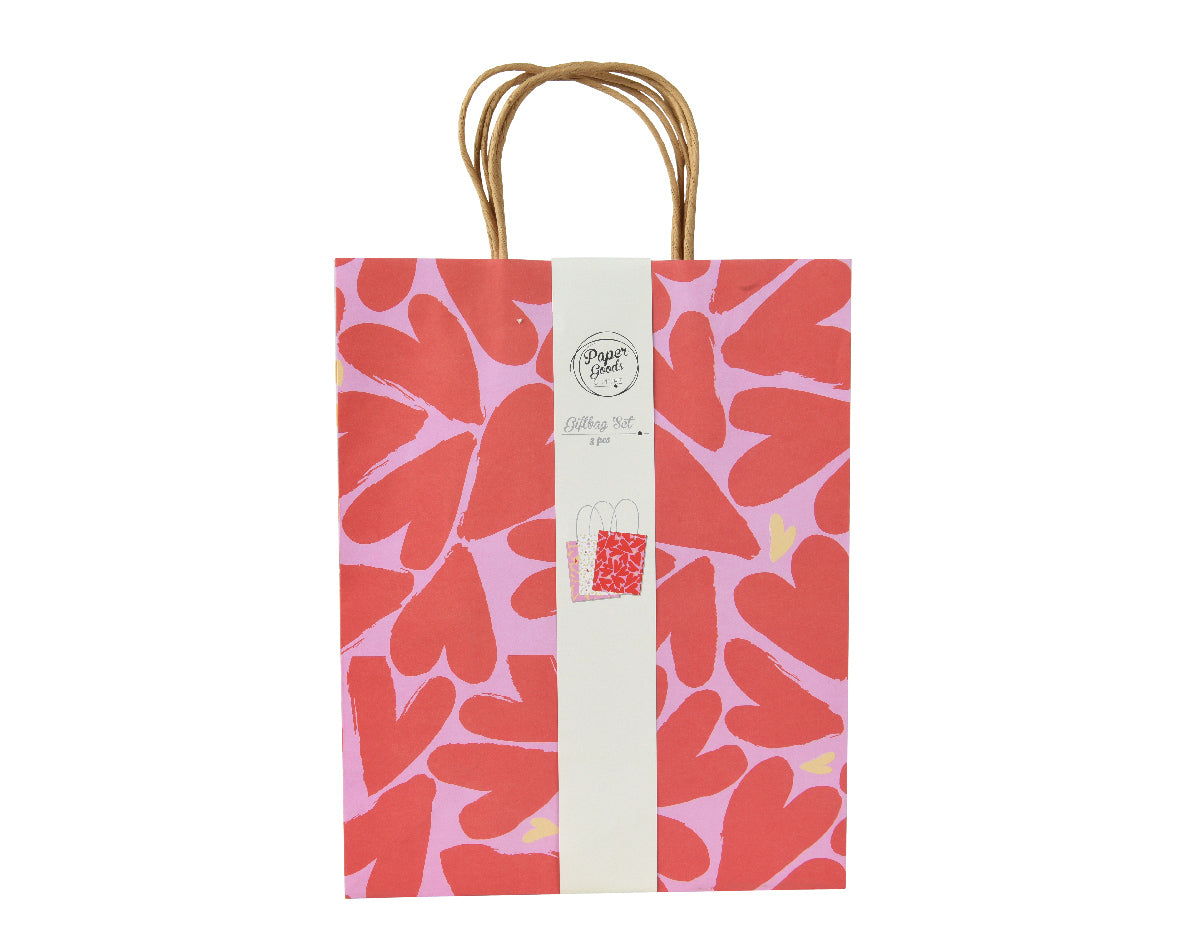 Papieren cadeauzak met handvat, rood met witte bladvormen en beige label