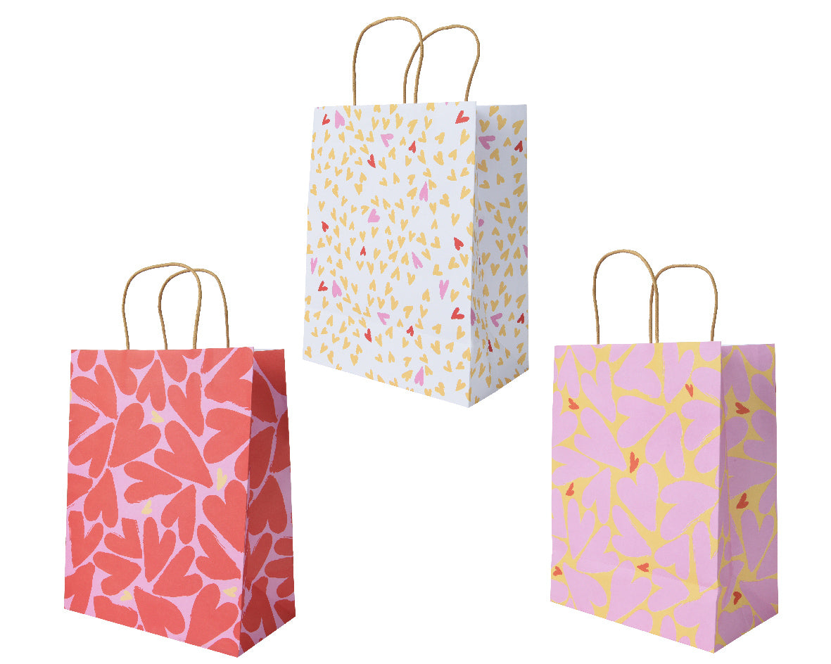 Papieren cadeauzakken met handvat, drie patronen: rood, paars en kleurrijke spikkels
