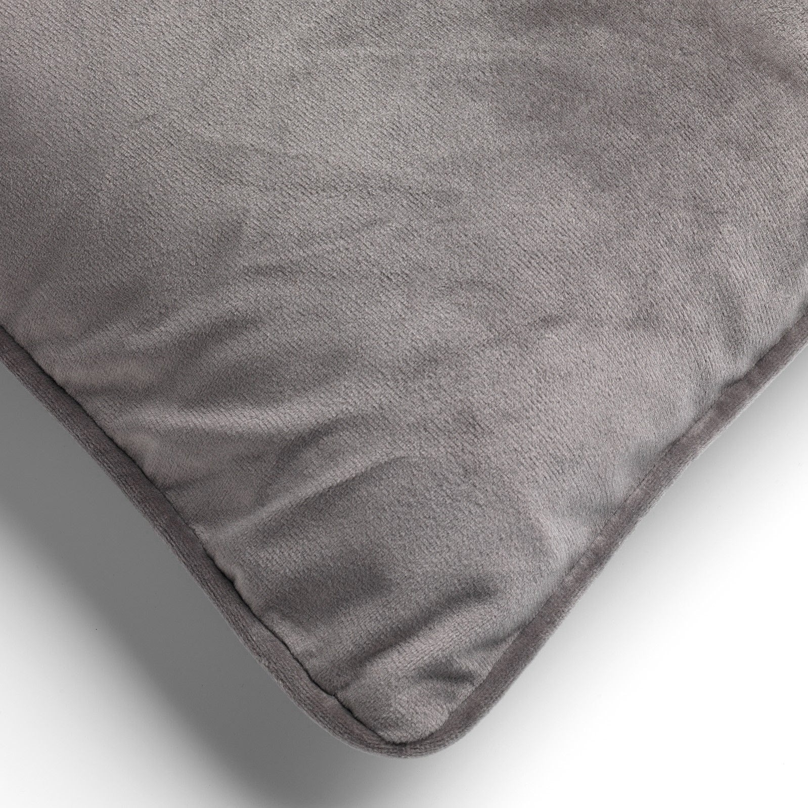 Taupe fluwelen sierkussen detail: hoeknaad en gladde stof, afgeronde vorm.