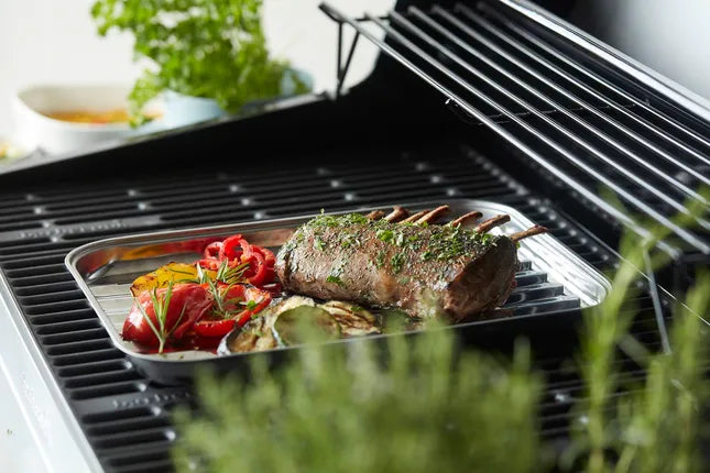 RVS grillpan met rooster, vlees en groenten op de barbecue