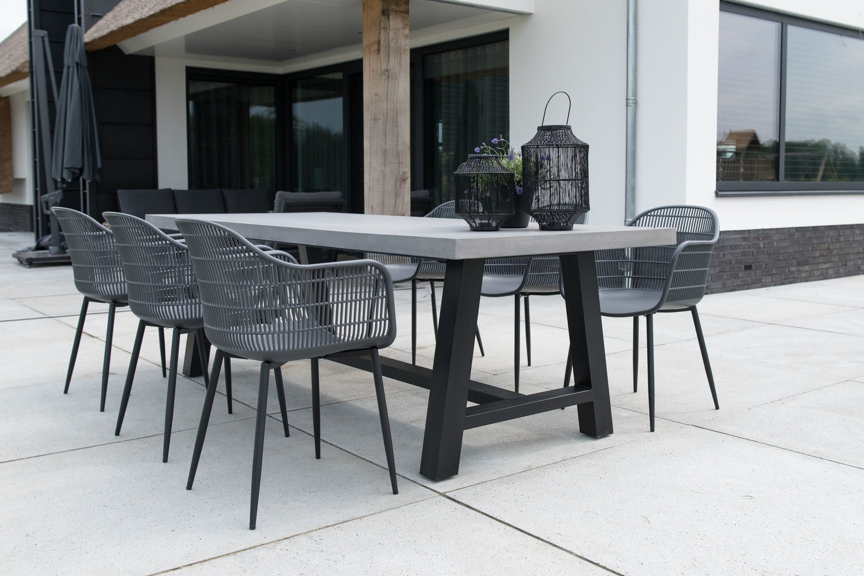 Set grijze tuinstoelen met geperforeerde rug, armleuningen en zwarte poten