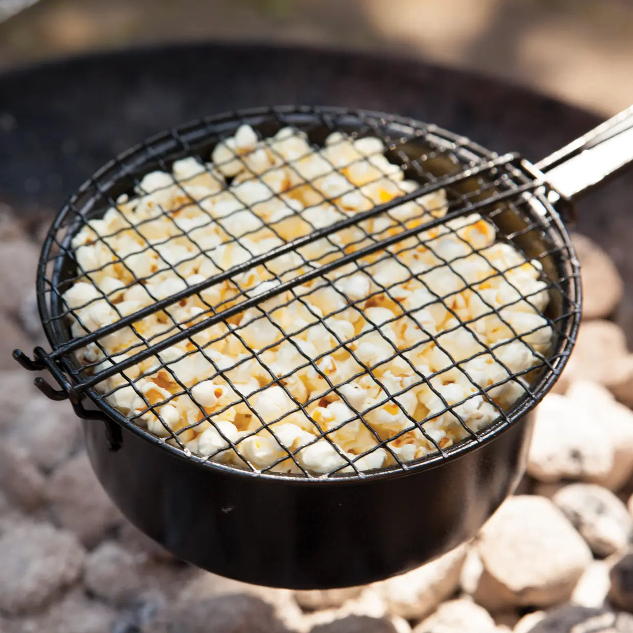 Popcornpan met gaasmandje vol popcorn