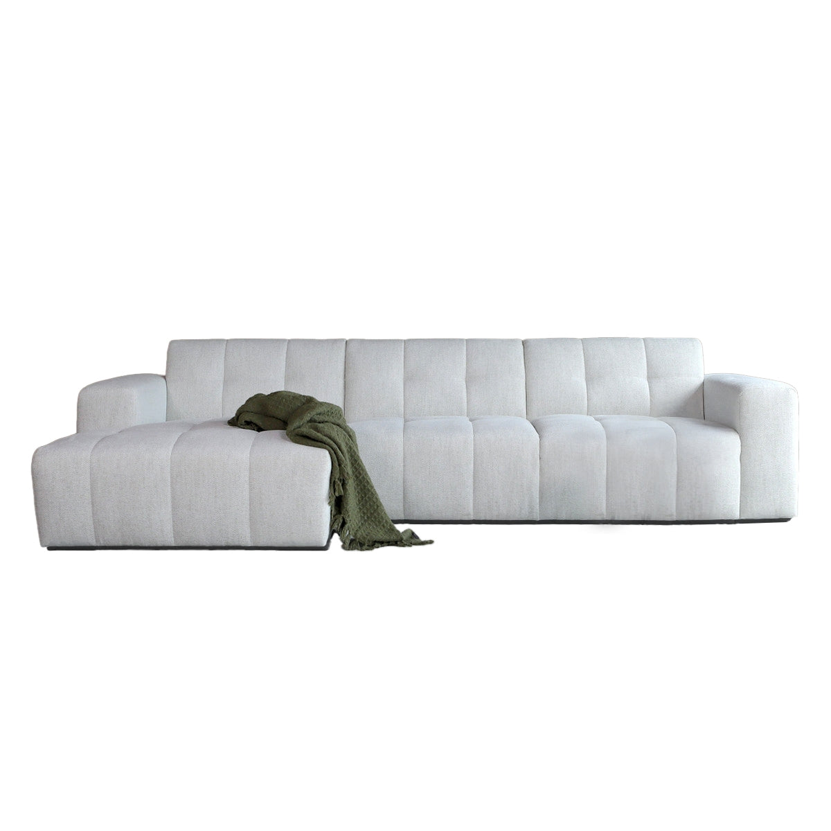 Witte stoffen bank met chaise longue links, met plaid over het zitgedeelte.