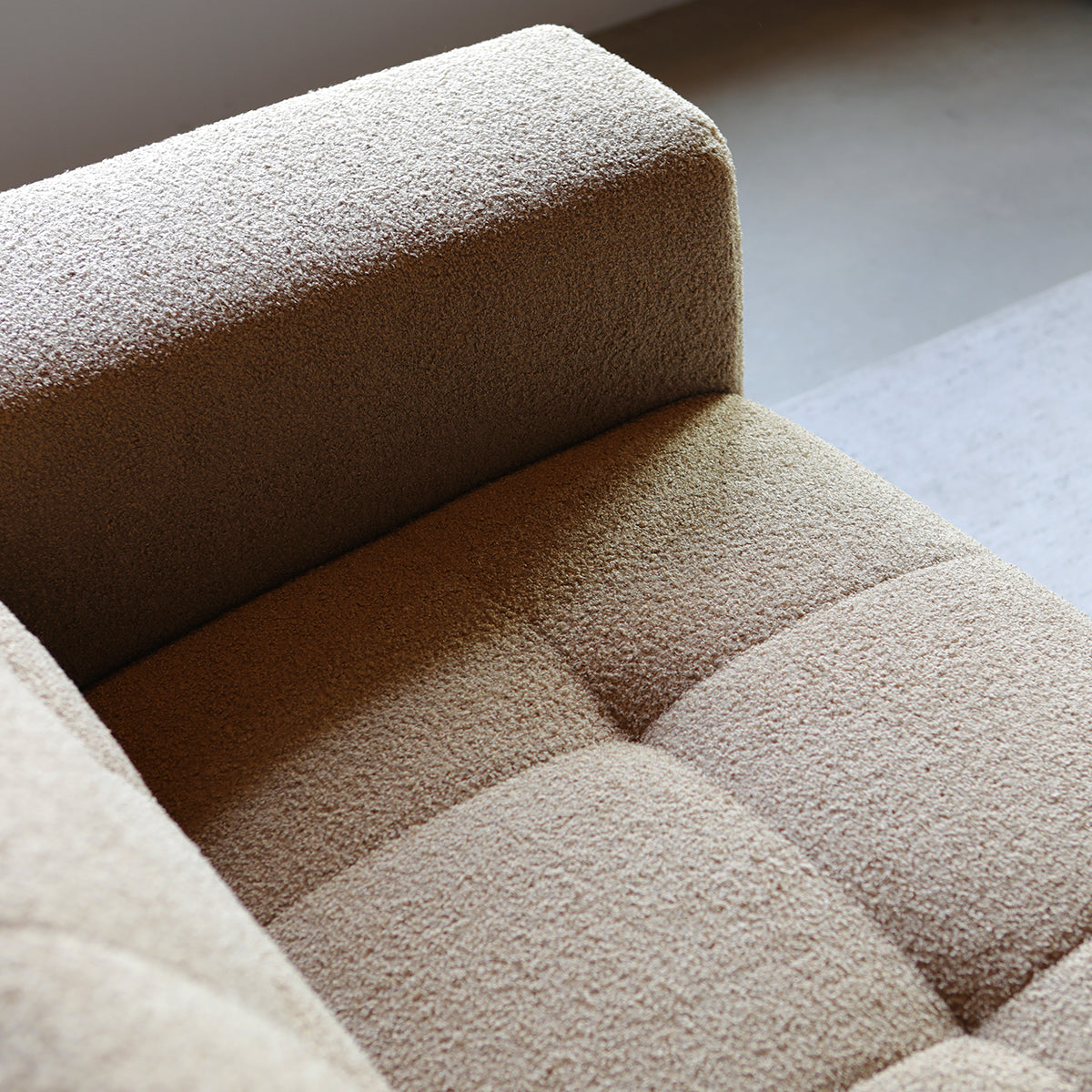 Beige gestoffeerde hoekbankzit met dikke zit- en rugkussens, close-up