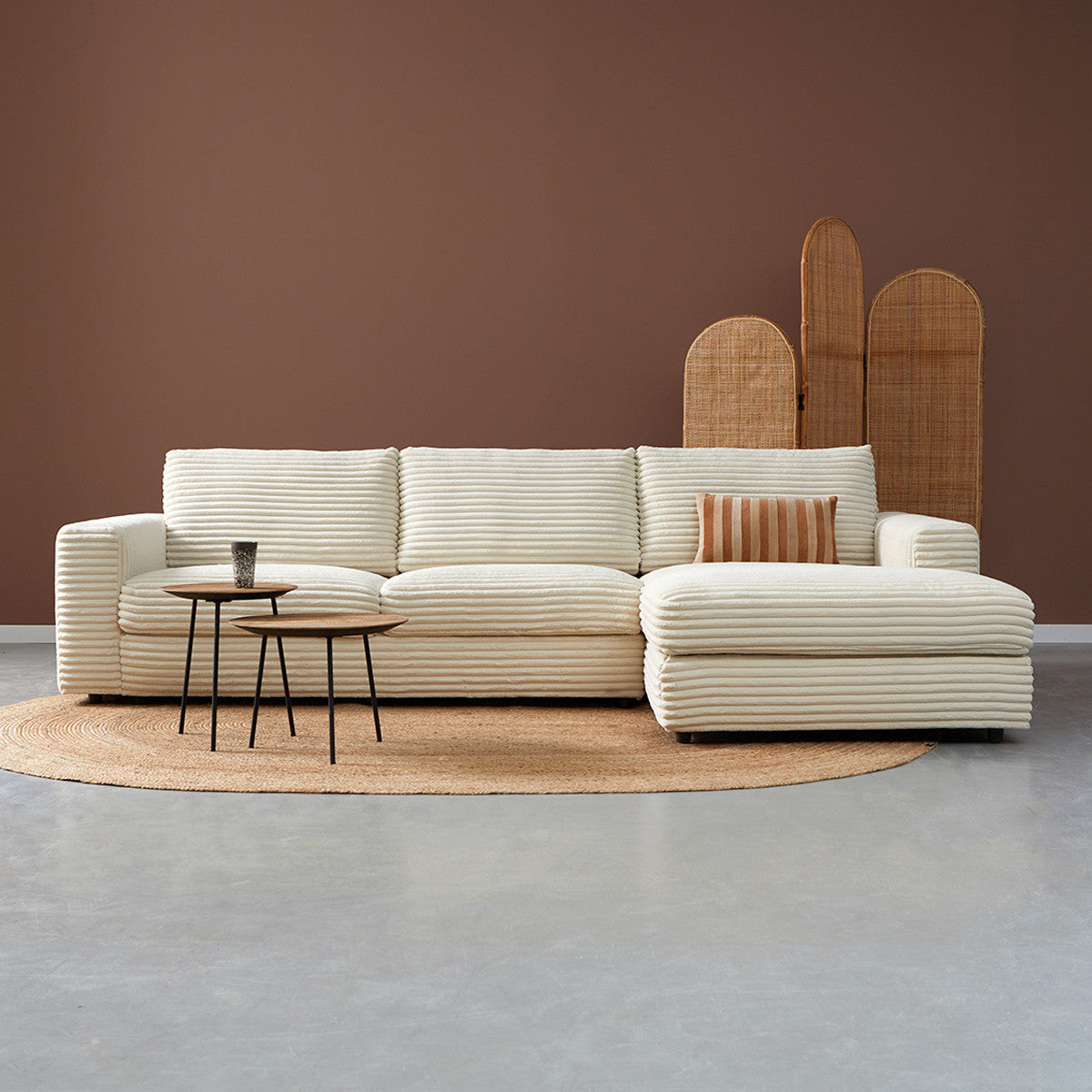 Roomset met crème hoekbank en chaise longue rechts, met brede zitkussens en opstaande rug.