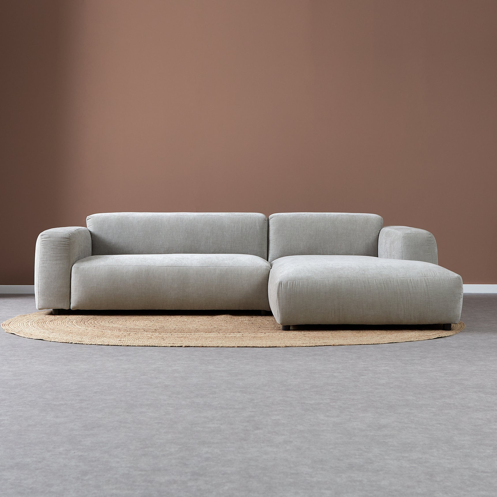 Lichtgrijze bank met chaise rechts, rechte zit en afgeronde armleuningen