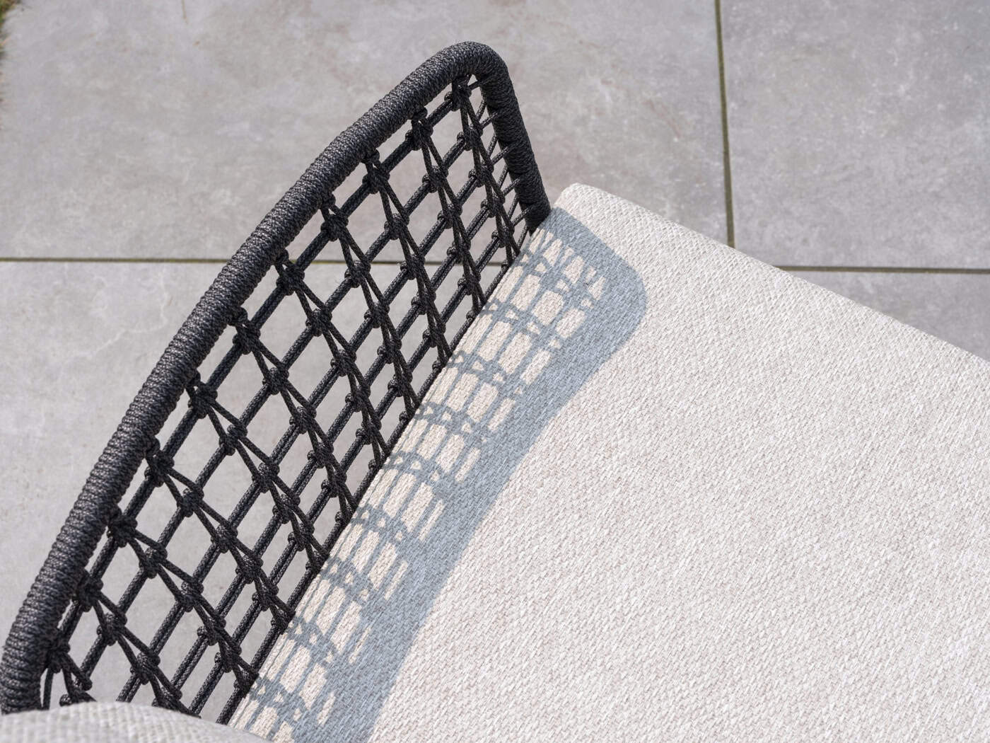 Rugleuning van diningstoel met zwart draadgaas en lichtbeige kussenvlak