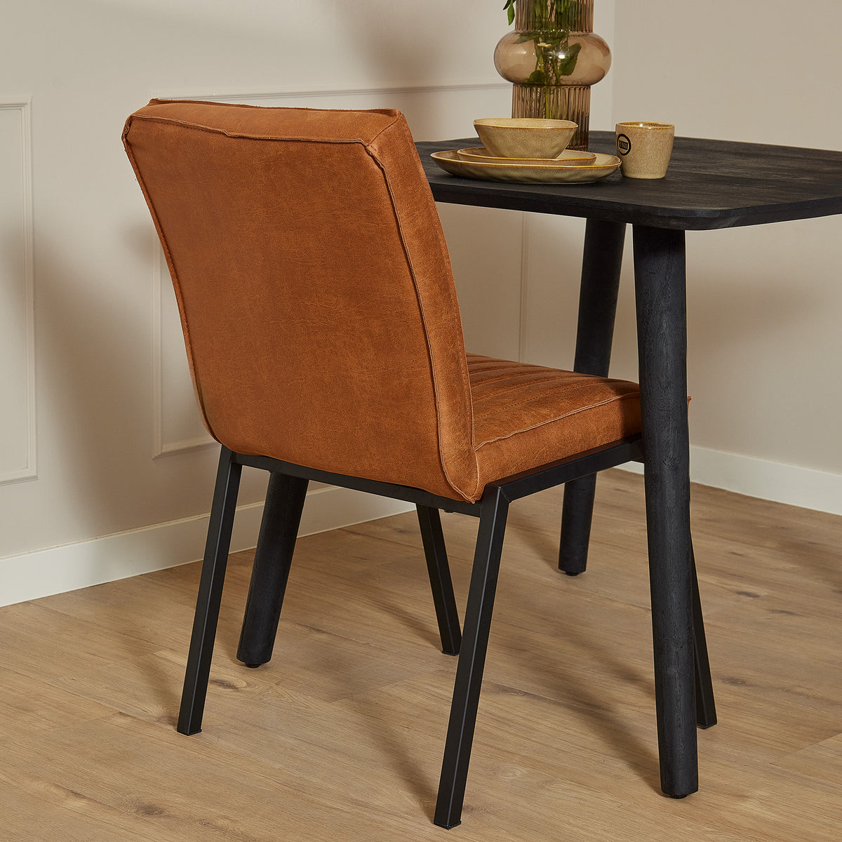Eetkamerstoel Tivoli, cognac bruine bekleding, hoge rug met siernaden en zwarte poten