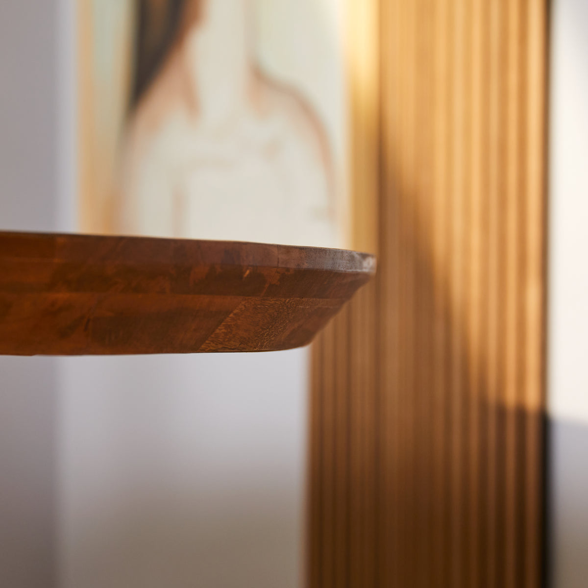 Ovaal houten tafelblad met afgeronde rand en zwart metalen onderstel, warm bruin