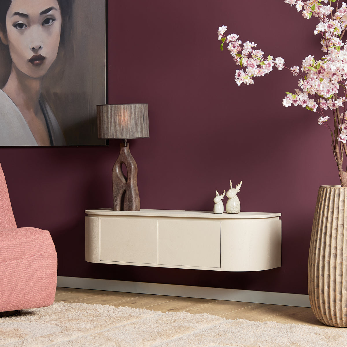 Zwevend tv-meubel met wit front en drie laden, op decoratieve opstelling