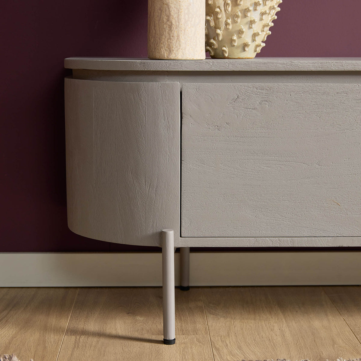 Zijaanzicht taupe tv-meubel met ladepaneel en houten poten