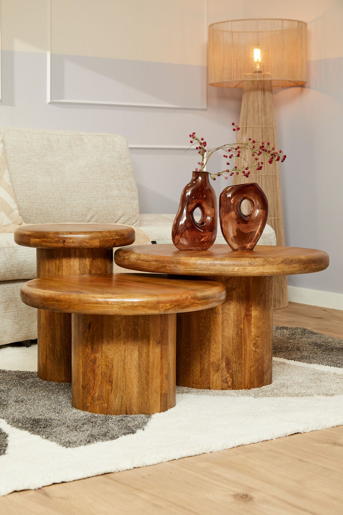 Houten salontafelset met 3 ronde tafels; bruin hout en cilindrische onderstellen