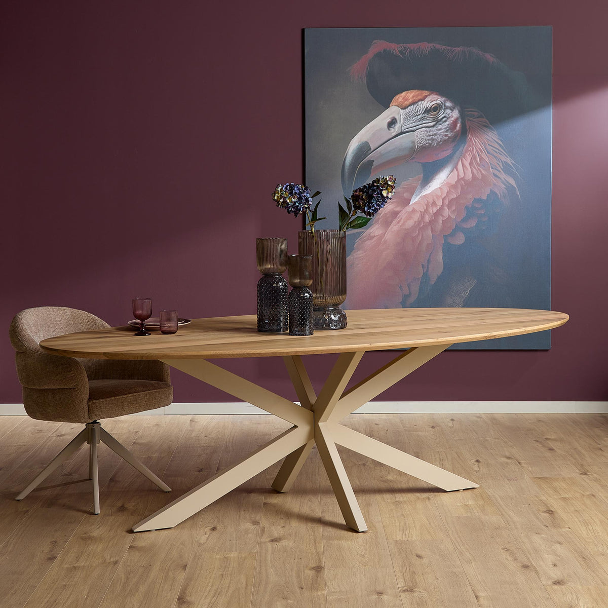 Ovale eettafel van licht eiken met zandkleurige X-poten en ronde bladrand.