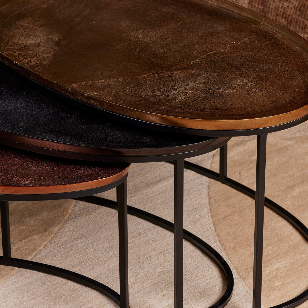 Ronde salontafels met bruin blad en donker metalen onderstel, close-up