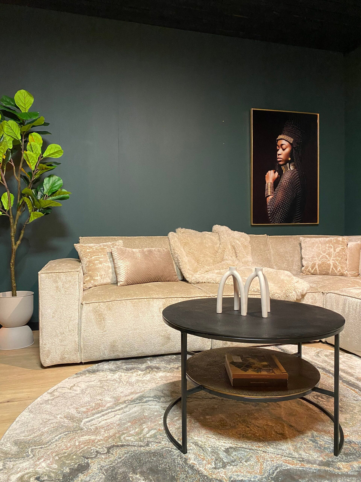 Zwarte ronde salontafel met drie witte beugels en metalen poten, met extra onderplank