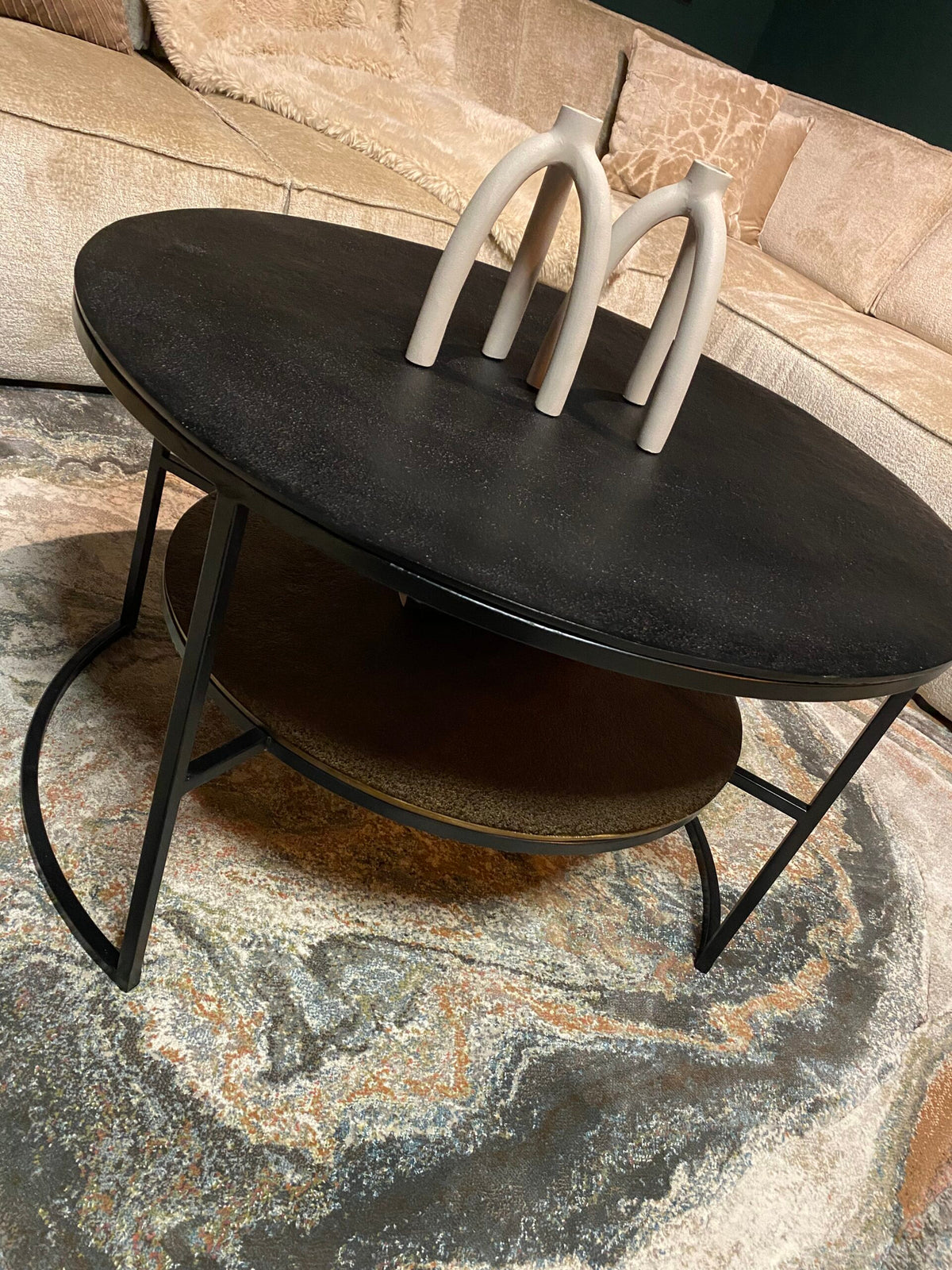 Zwarte eivormige ronde salontafel met witte beugels en metalen pootjes, opklepbaar blad