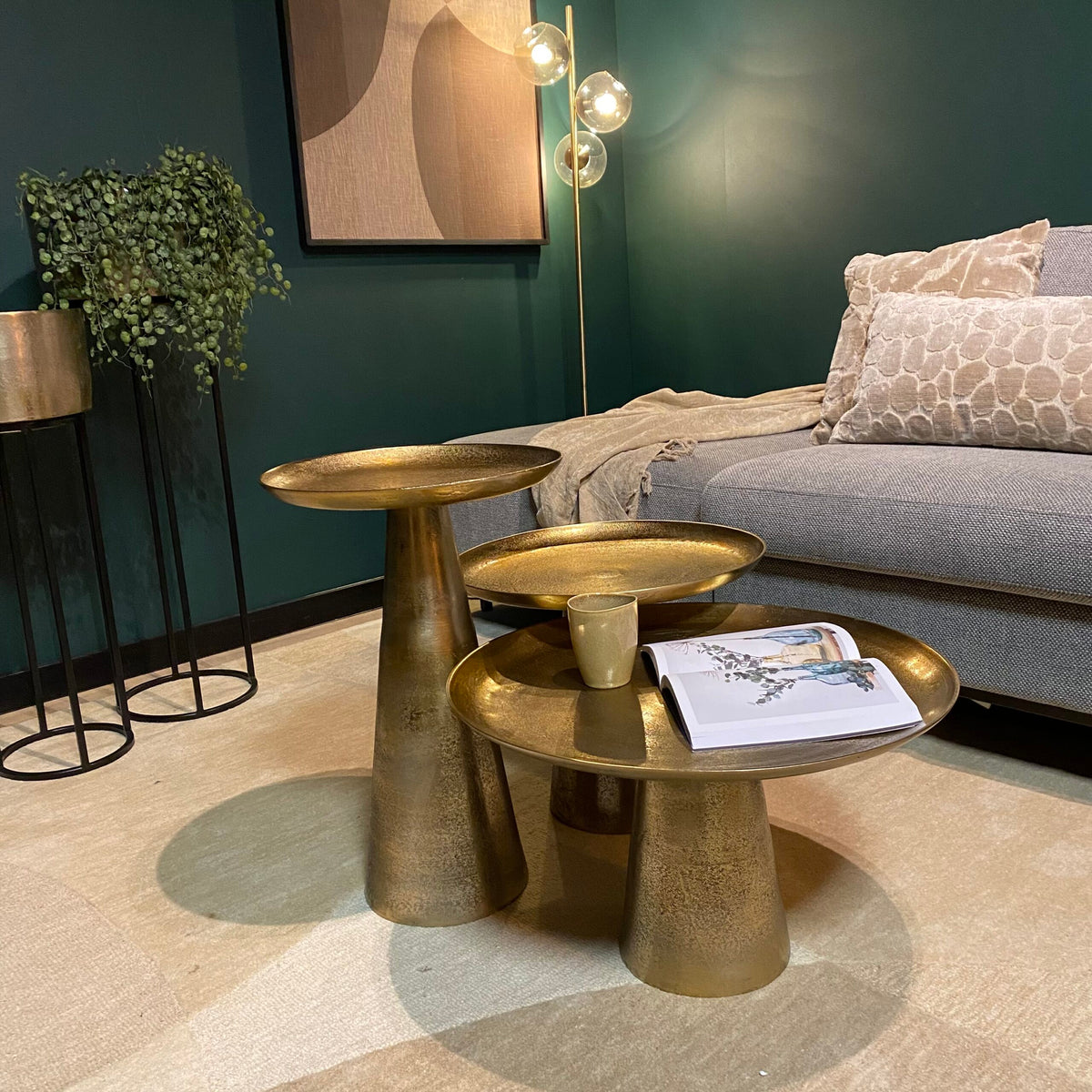 Ronde salontafelset met goudkleurige bladen en hoge middenpilaren, met mok