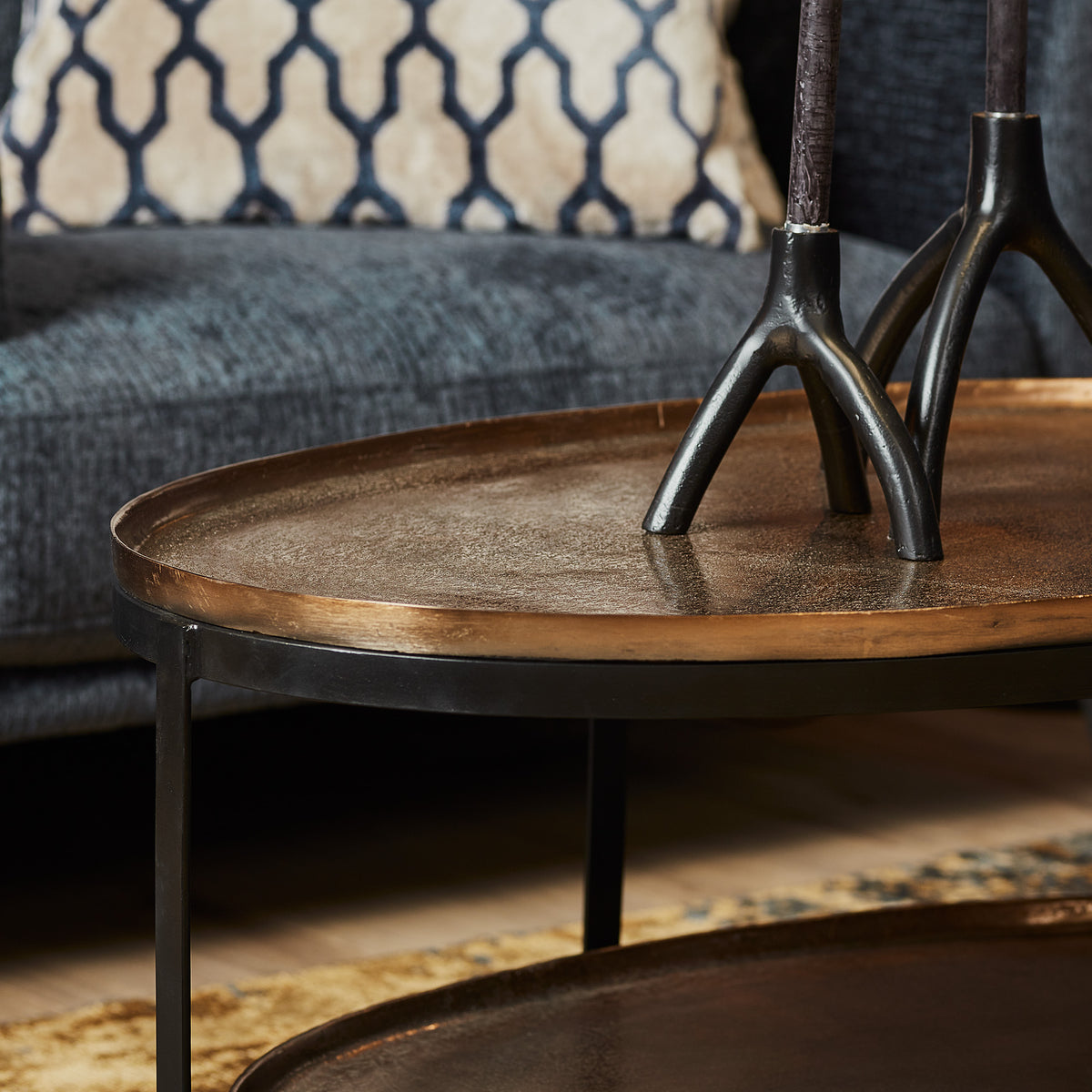 Ovale houten tafelblad met zwart metalen poten onder de salontafel Kate.