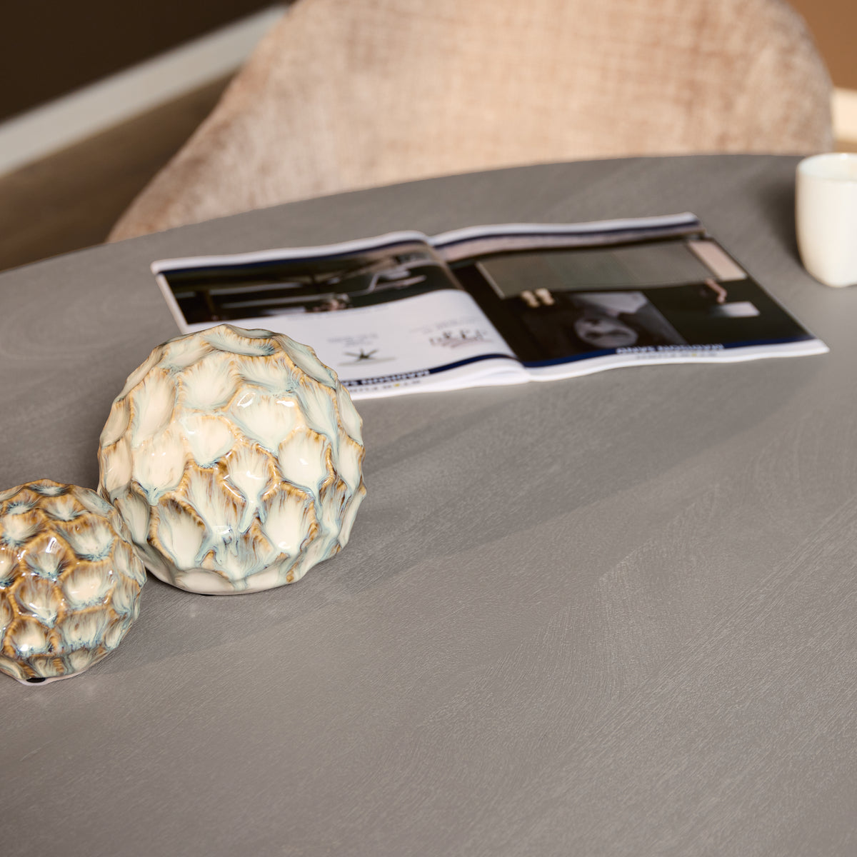 Taupe eettafelblad met decor en tijdschrift op het oppervlak