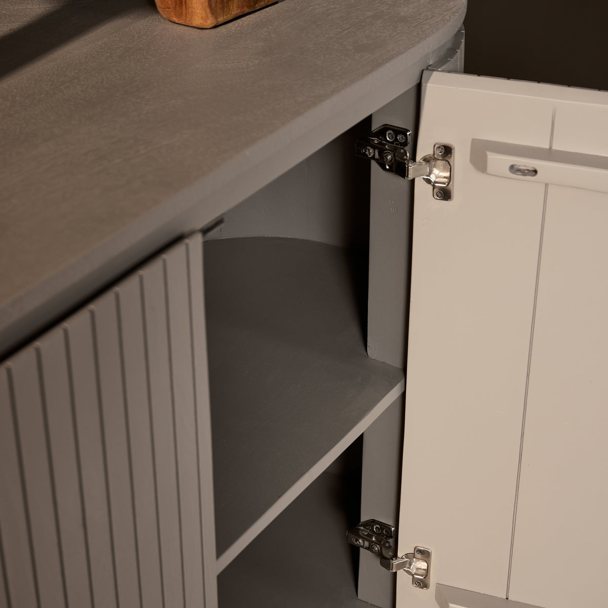 Dressoir detail van scharnier en deur met metalen beslag, grijs-taupe.
