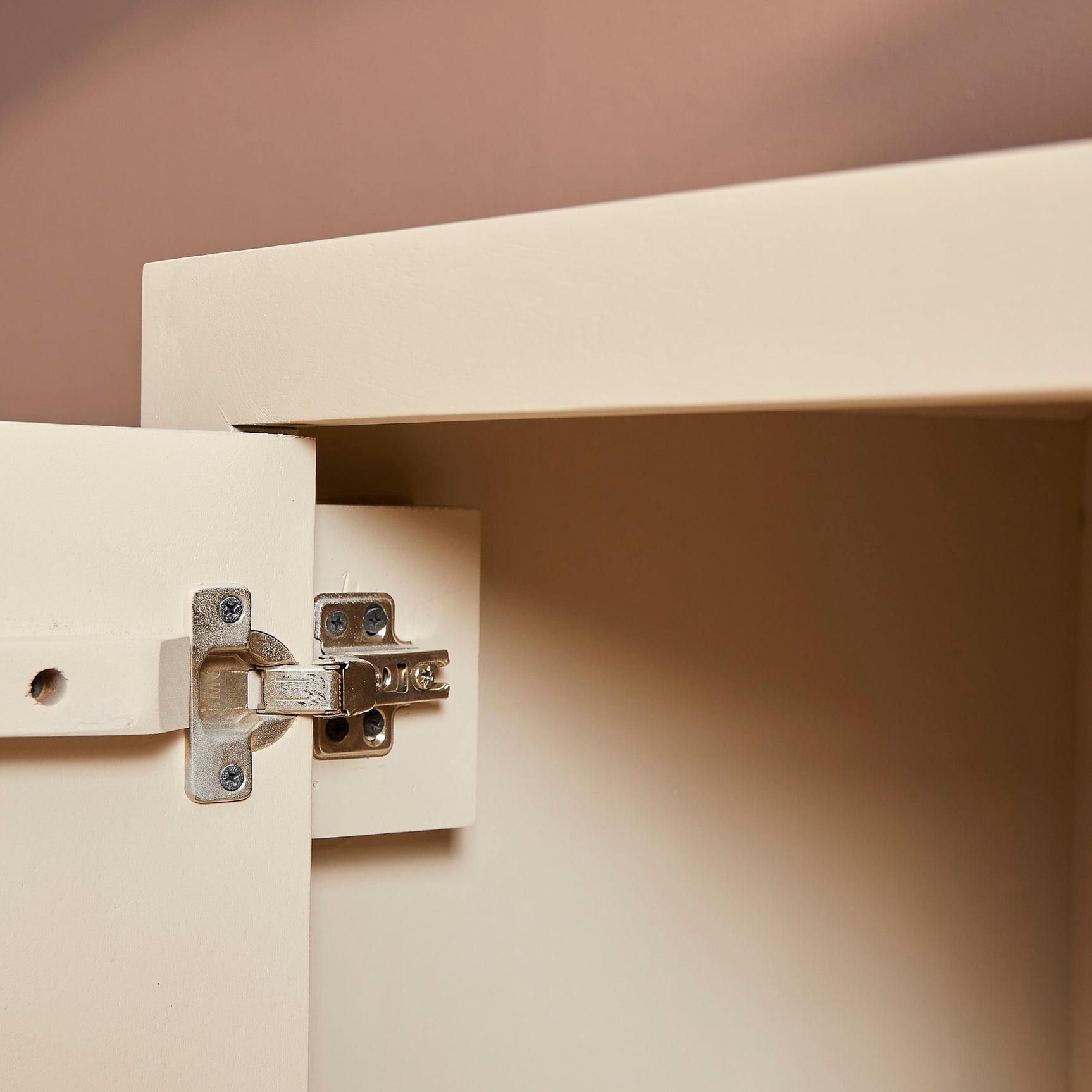 Dressoir met open deur en scharnierbeslag, zichtbaar interieur met legplank.