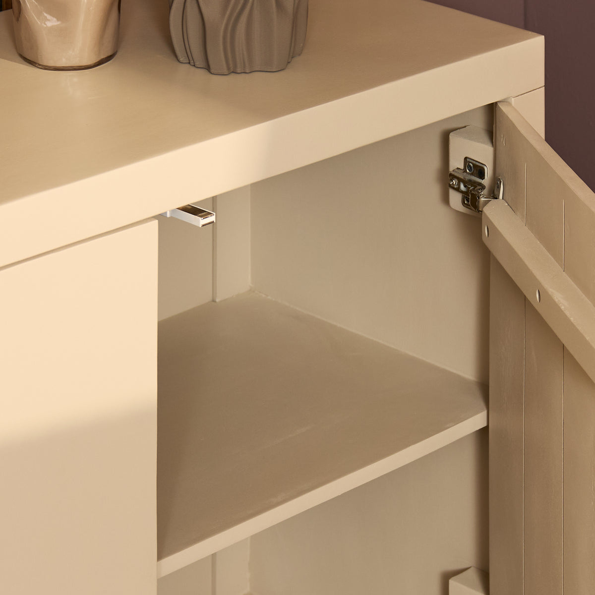 Lichtkleurig dressoir, open kast met legplanken en scharnierbeslag aan de binnenkant
