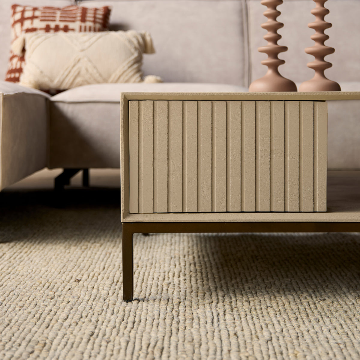 Vierkante salontafel zandkleur met ladefront met verticale ribbels en open vak aan de zijkant.