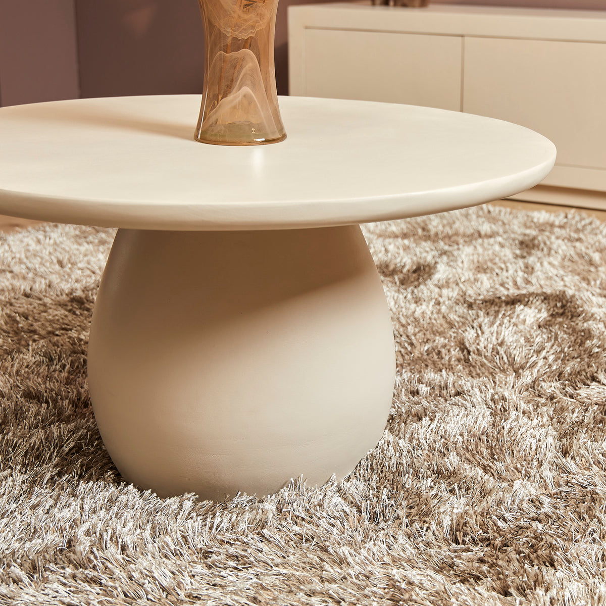 Ronde salontafel met wit blad en bolvormig onderstel, taps toelopend