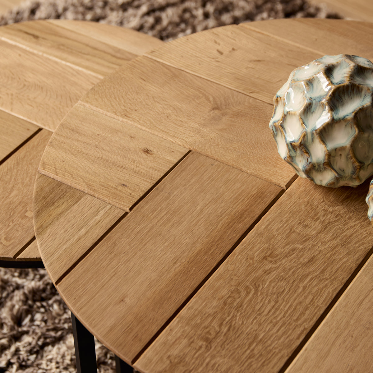 Close-up van rond eiken tafelblad met zichtbare houtnerf en diagonale voegen
