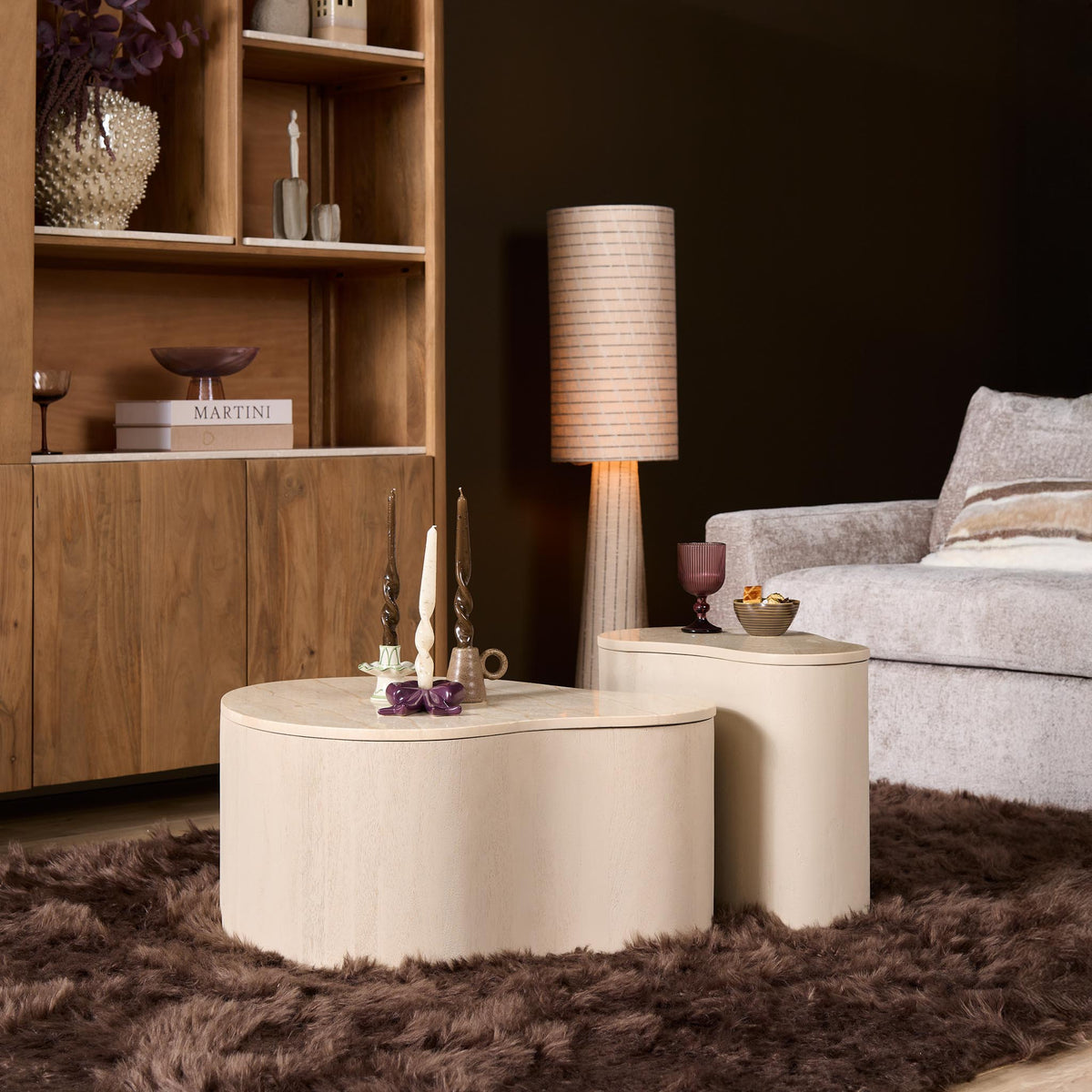 Zandkleurige ronde salontafel met beige blad en lage, brede ronde basis