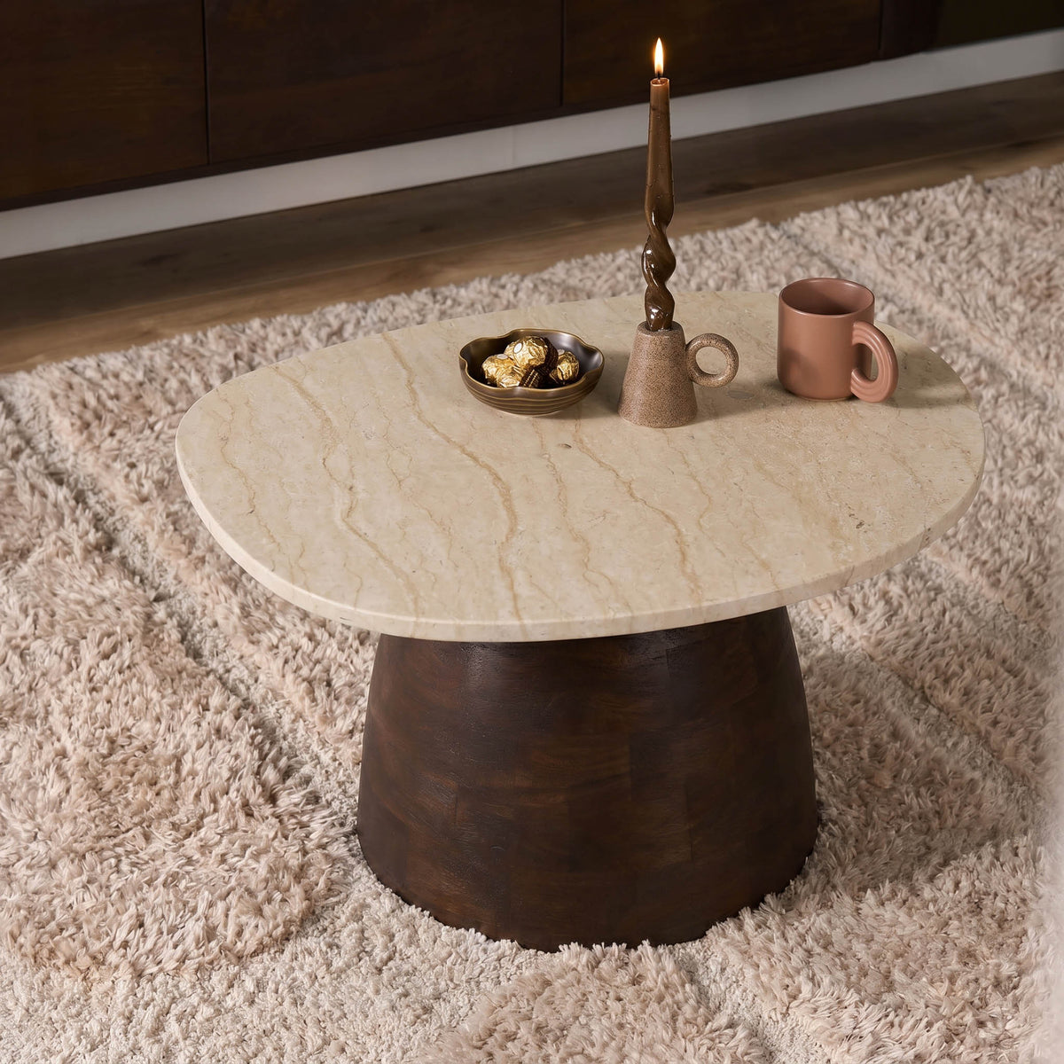 Ronde salontafel met beige marmeren blad en donkere houten voet voor woonkamergebruik