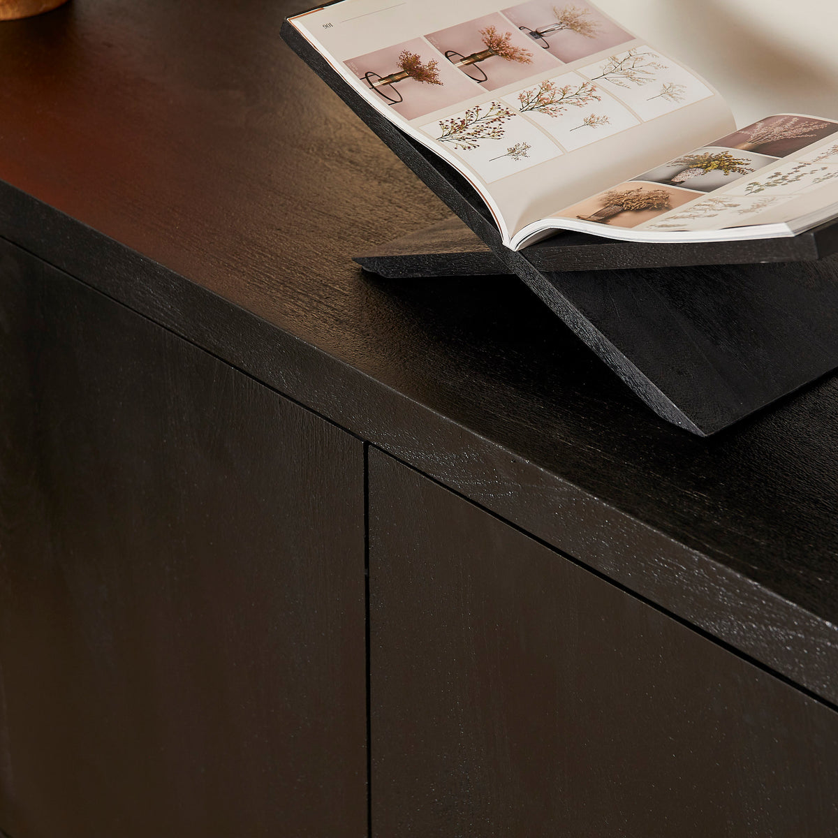 Zwart dressoir met vlakke bovenplaat en gladde frontpanelen, detail opberggedeelte.