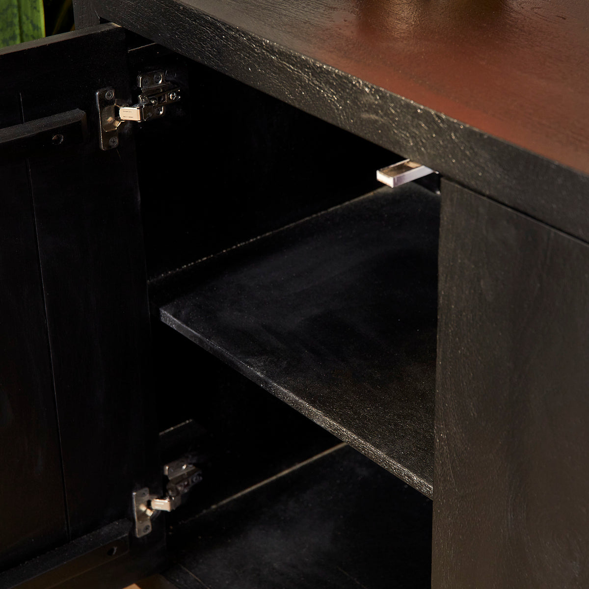 Zwart dressoir met open binnenvakken en scharnierende planken, interieurdetail.