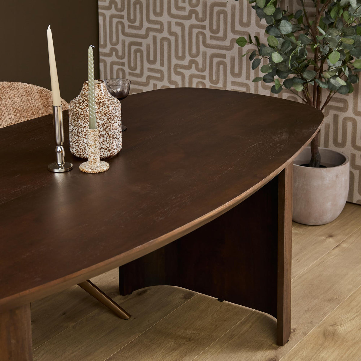 Bruine eettafel met afgerond ovaal blad en taps toelopende houten poten