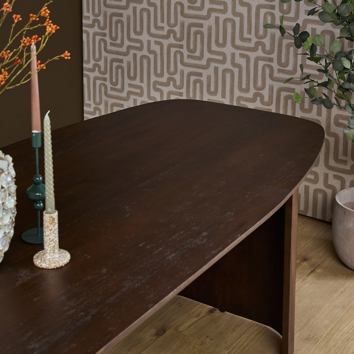 Eettafel van bruin hout met afgerond blad en stevige poot, geschikt voor dagelijks gebruik