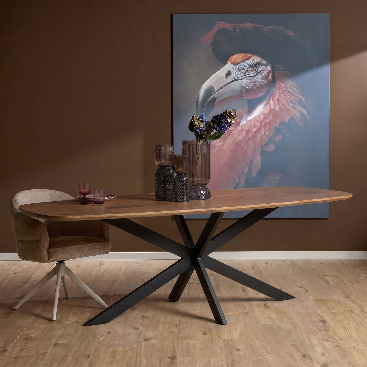 Ovale eettafel met bruin houten blad en zwart metalen kruisvormig pootonderstel.