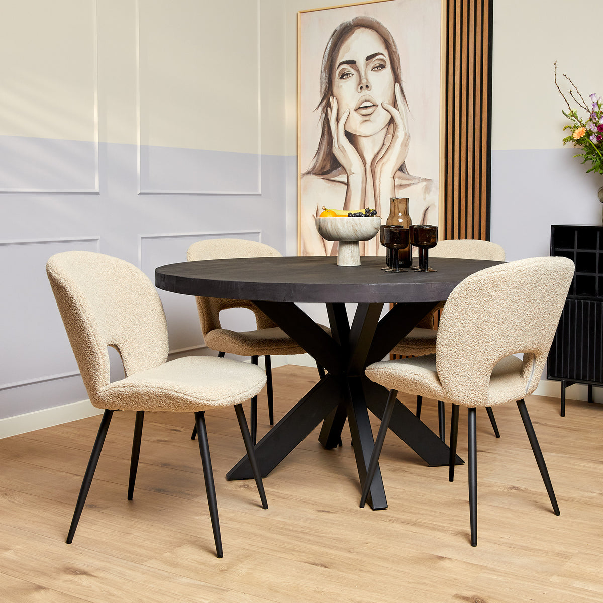 Ronde eettafel met zwart blad en beige kuipstoelen eromheen