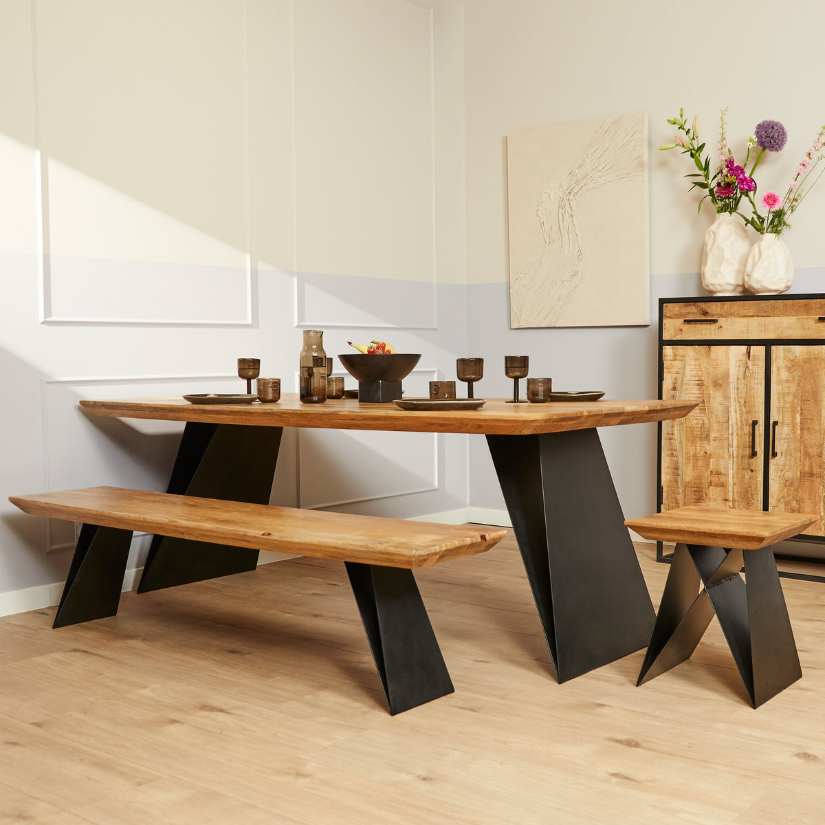 Eetkamertafel met eikenhouten blad en zwarte schuine poten, met houten bankje