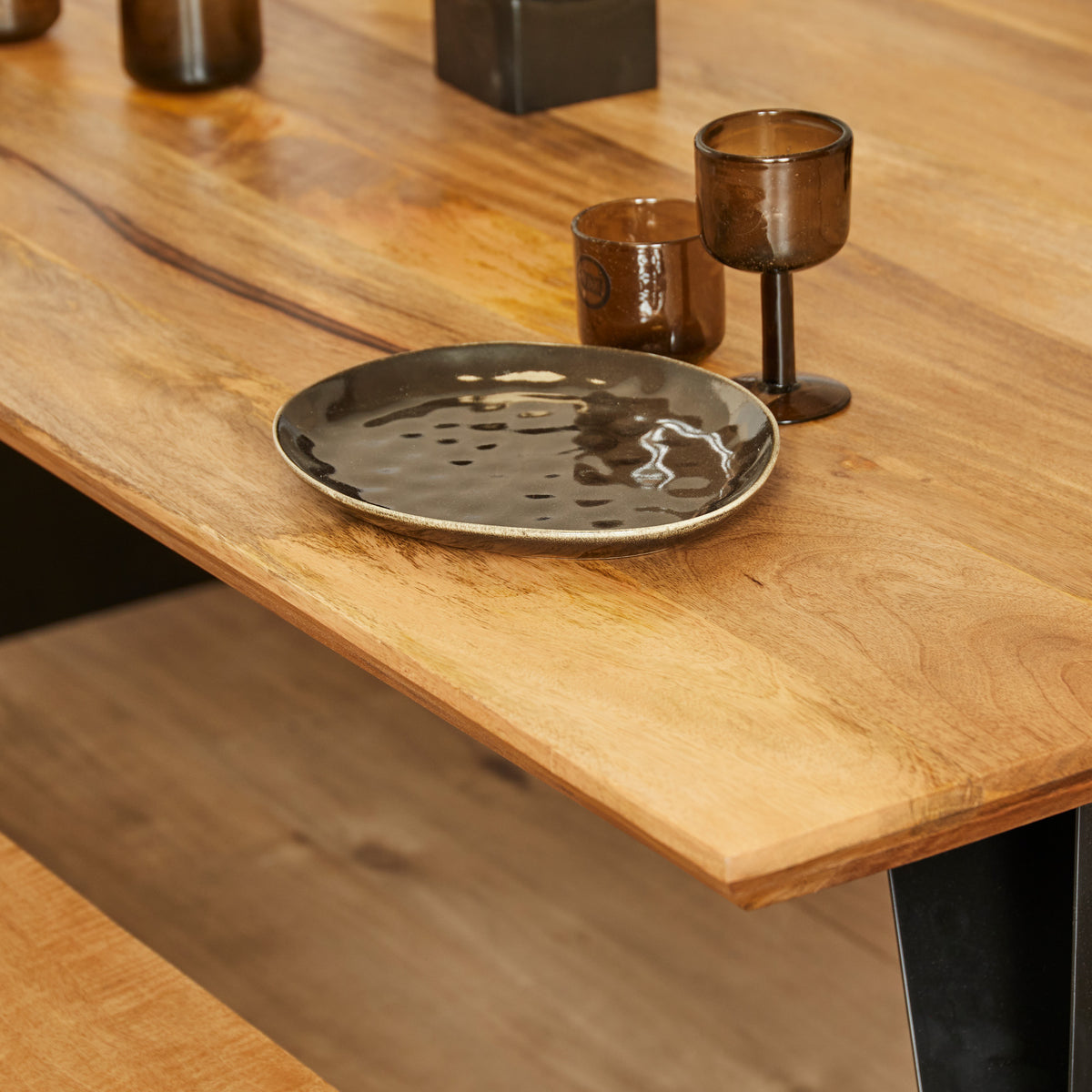 Eetkamertafel met eikenhouten blad en zwarte poot, met kaarsen en schaal