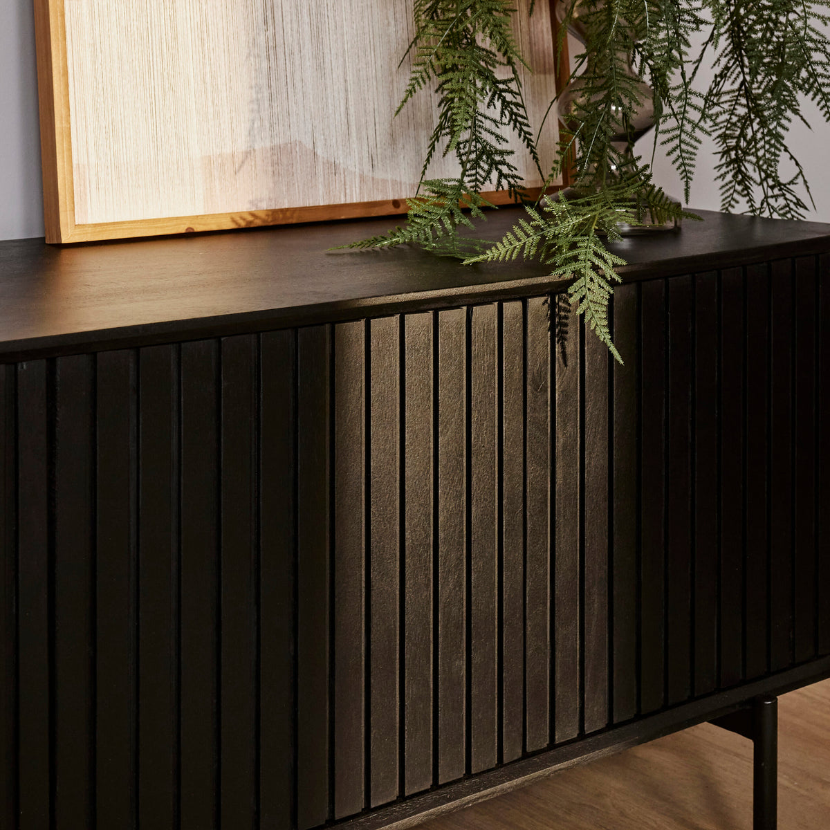 Zijaanzicht tv-meubel met ribbelpanelen en donker houten front, op slanke pootjes