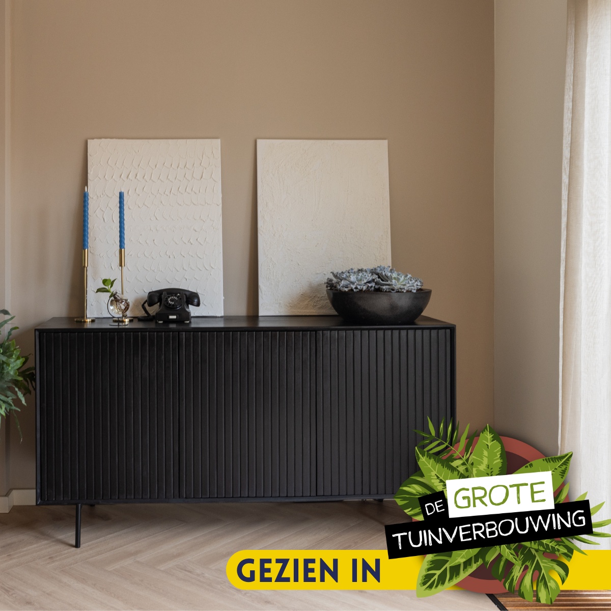 Zwart dressoir met vier deuren en verticale groeven, op slanke poten.